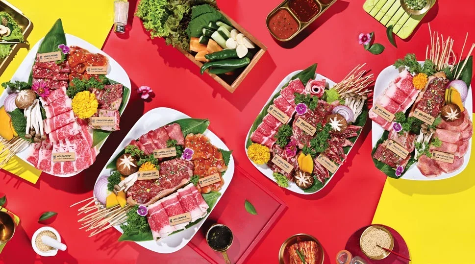 An assortment of Koba Korean BBQ dishes arranged on a red surface